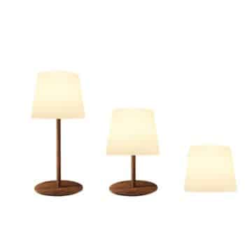 Three lamps with wooden bases and white lampshades are shown, each tilted further to the right, progressing from upright to almost lying flat.