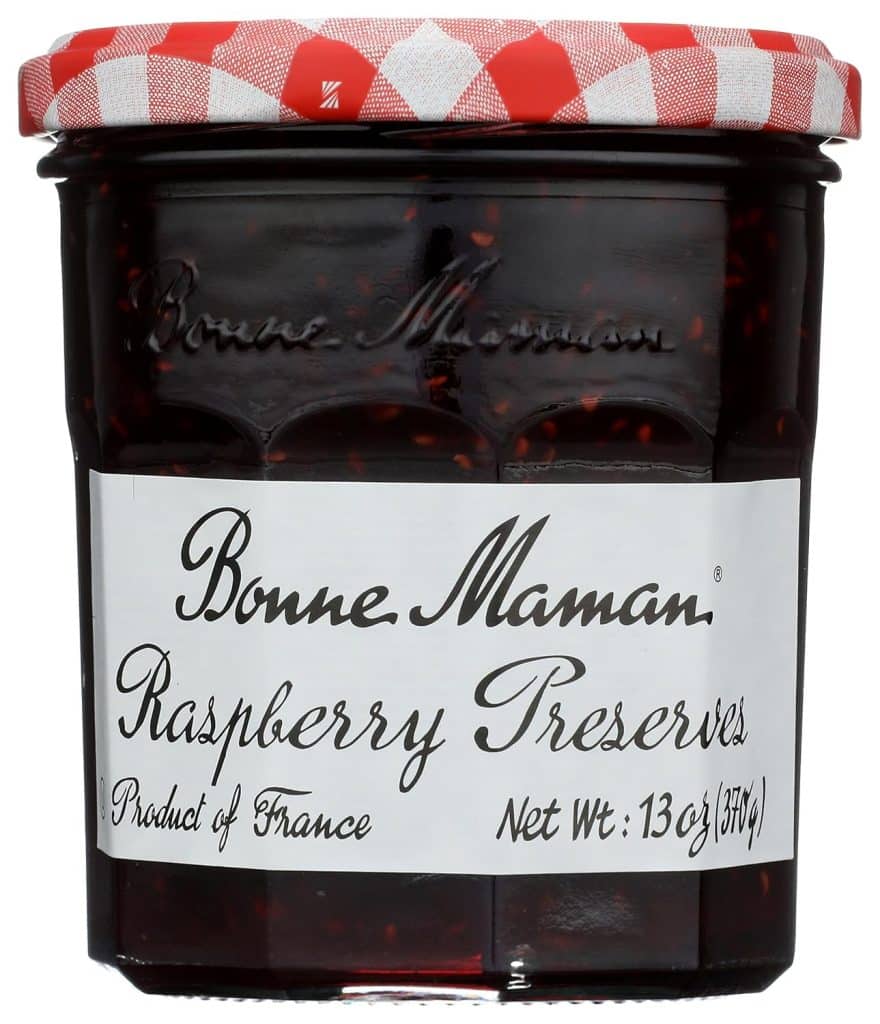 A glass jar of Bonne Maman Raspberry Preserves with a red and white checkered lid and a white label—perfect for adding a fruity touch to your favorite overnight oats recipe. Product of France, Net Wt: 13 oz (370g).