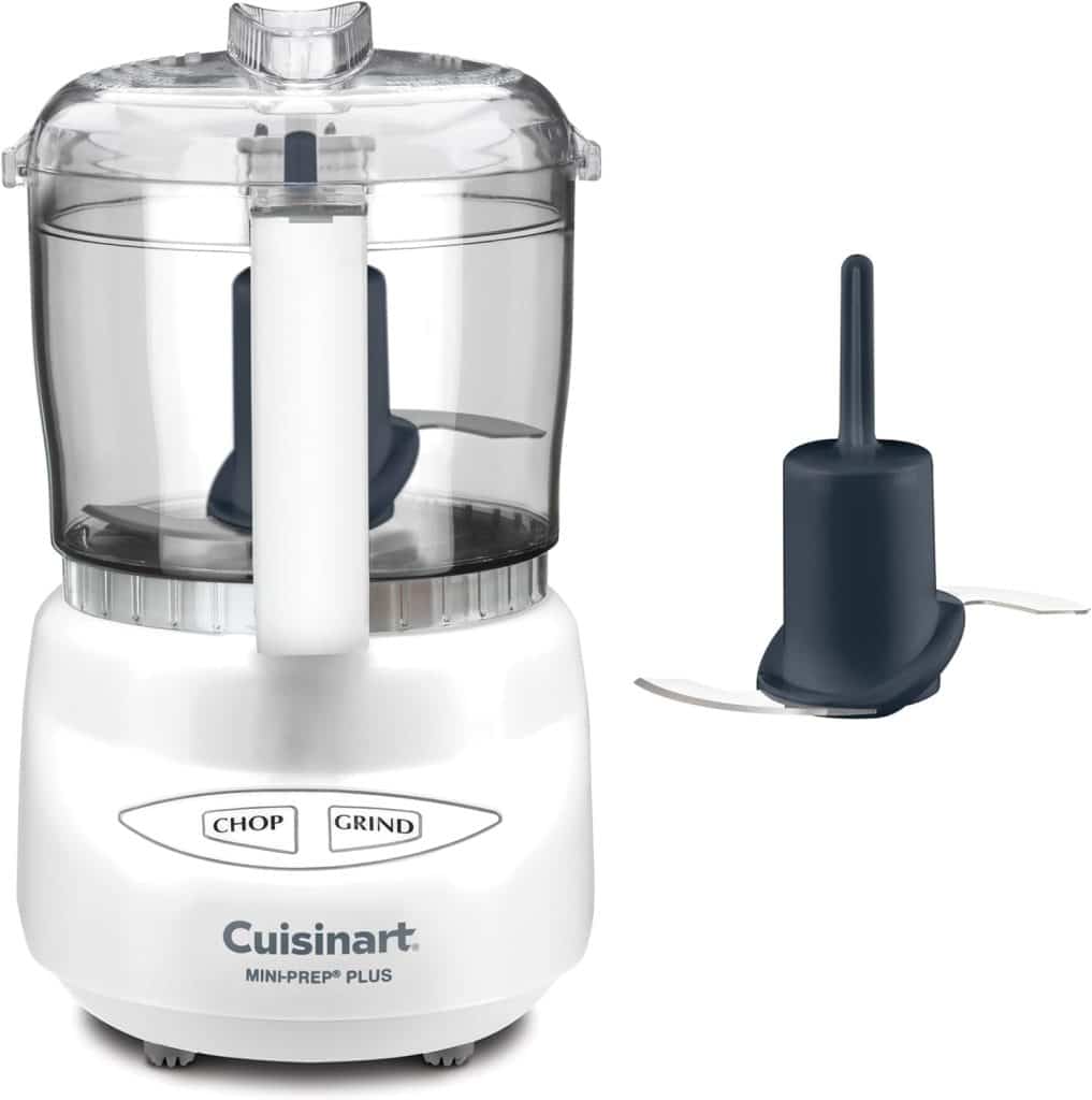 A white Cuisinart Mini-Prep Plus food processor with a clear lid is shown alongside an extra detachable blade. Its front features "Chop" and "Grind" buttons—perfect for prepping ingredients for your favorite overnight oats recipe.