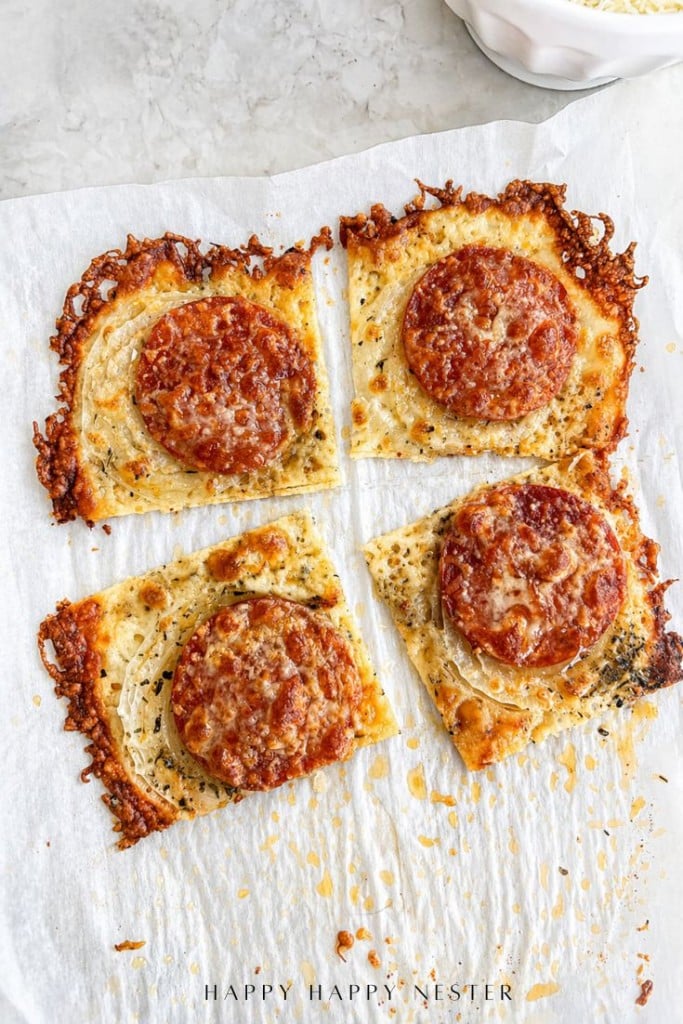 Four square slices of crispy cheese bread topped with pepperoni and grated cheese, arranged on parchment paper with browned, bubbly edges—perfect as a savory side for your favorite onion ring pizza recipe.
