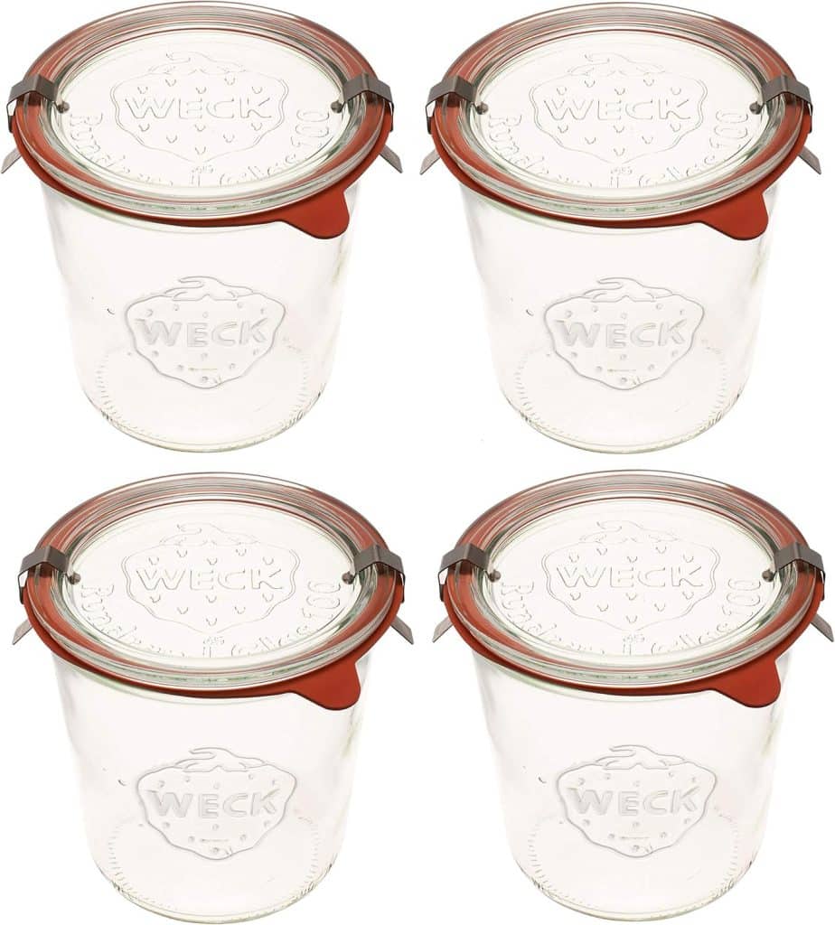 Four clear glass Weck jars with lids, orange rubber seals, and metal clips arranged in a two-by-two grid on a white background—perfect for prepping your favorite overnight oats recipe.