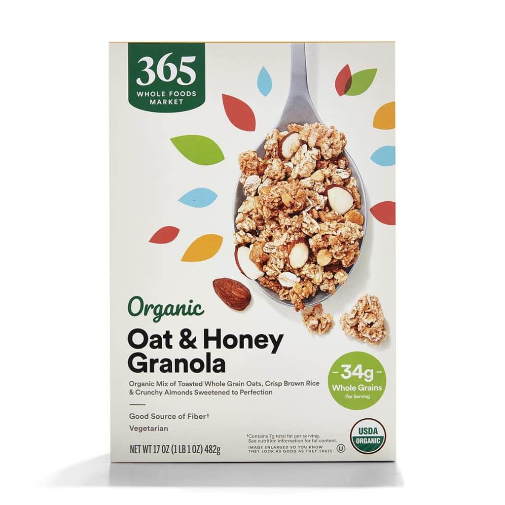 A box of 365 Whole Foods Market Organic Oat & Honey Granola, featuring a spoonful with almonds, colorful leaf graphics, and labels for organic, vegetarian, and 34g whole grains—perfect as a topping for your favorite overnight oats recipe.