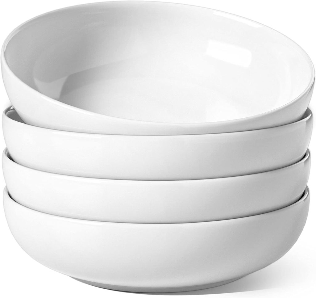 Four plain white ceramic bowls are stacked neatly in a pile against a white background, perfect for serving your favorite simple pasta sauce recipe.