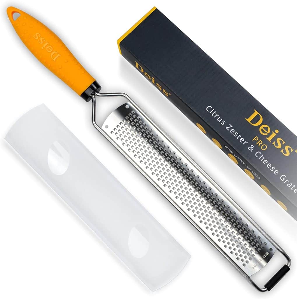 A Deiss Pro citrus zester and cheese grater with an orange handle, shown with a protective cover and its black and yellow packaging box—perfect for zesting lemons for your favorite lemon aioli sauce recipe.