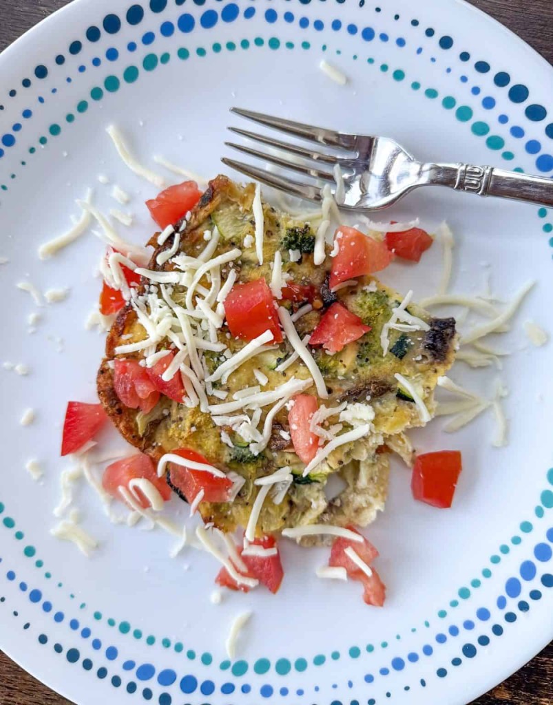 Easy crustless vegetable quiche sliced in a pie dish, perfect for simple and lazy Saturday morning breakfast ideas.