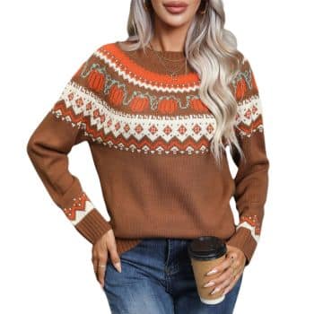 Woman with long blonde hair wearing a brown, orange, and white patterned sweater and blue jeans, holding a to-go coffee cup, standing against a white background.