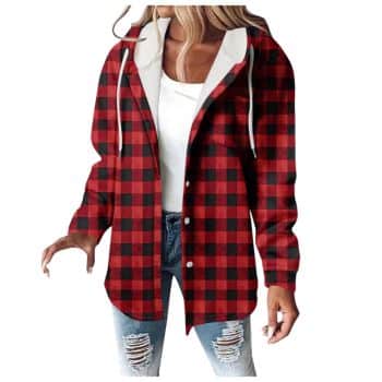 A woman wearing a red and black plaid hooded jacket over a white top and ripped blue jeans.