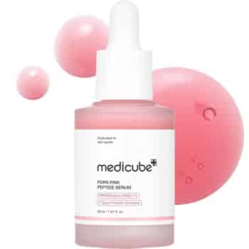 A pink-tinted dropper bottle labeled “medicube PDRN Pink Peptide Serum” stands in front of pink liquid bubbles on a white background.