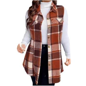 Woman wearing a white turtleneck sweater under a sleeveless, long, brown and orange plaid button-up vest with pockets, and black pants.