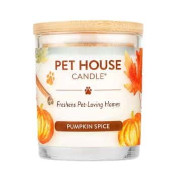 A glass candle labeled “Pet House Candle, Freshens Pet-Loving Homes, Pumpkin Spice” with a wooden lid, decorated with pumpkins, cinnamon sticks, and fall leaves on the label.
