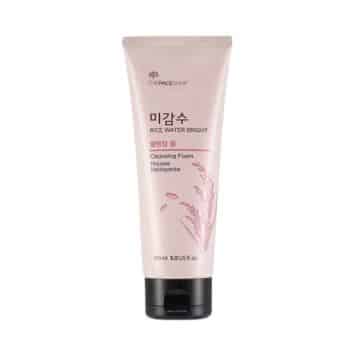 A pink tube of The Face Shop Rice Water Bright Cleansing Foam, 150 ml, with Korean and English text and images of rice grains on the front.