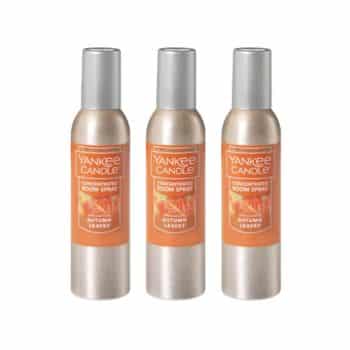 Three cans of Yankee Candle Concentrated Room Spray in the Autumn Leaves scent, each with an orange label and silver cap, are arranged side by side against a white background.