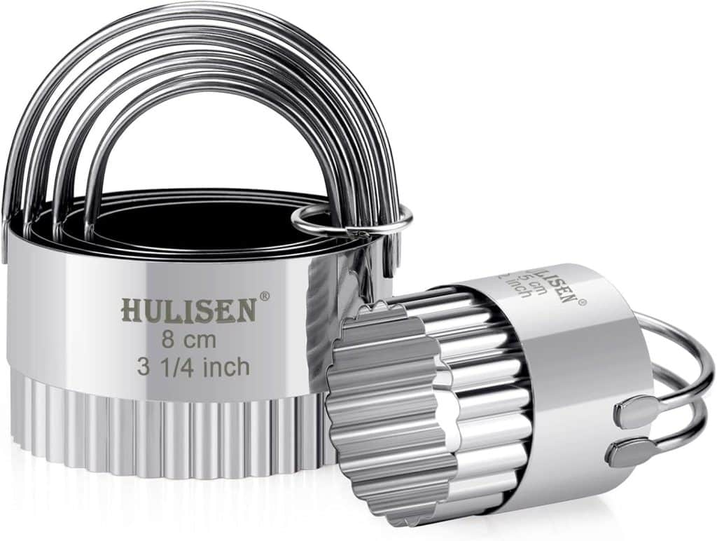 A set of metal round cookie or biscuit cutters with fluted edges, perfect for shaping shortbread or pressing patterns with a cookie stamp, nested together. One cutter is shown separately, and the brand “HULISEN” with size info is visible on the cutters.