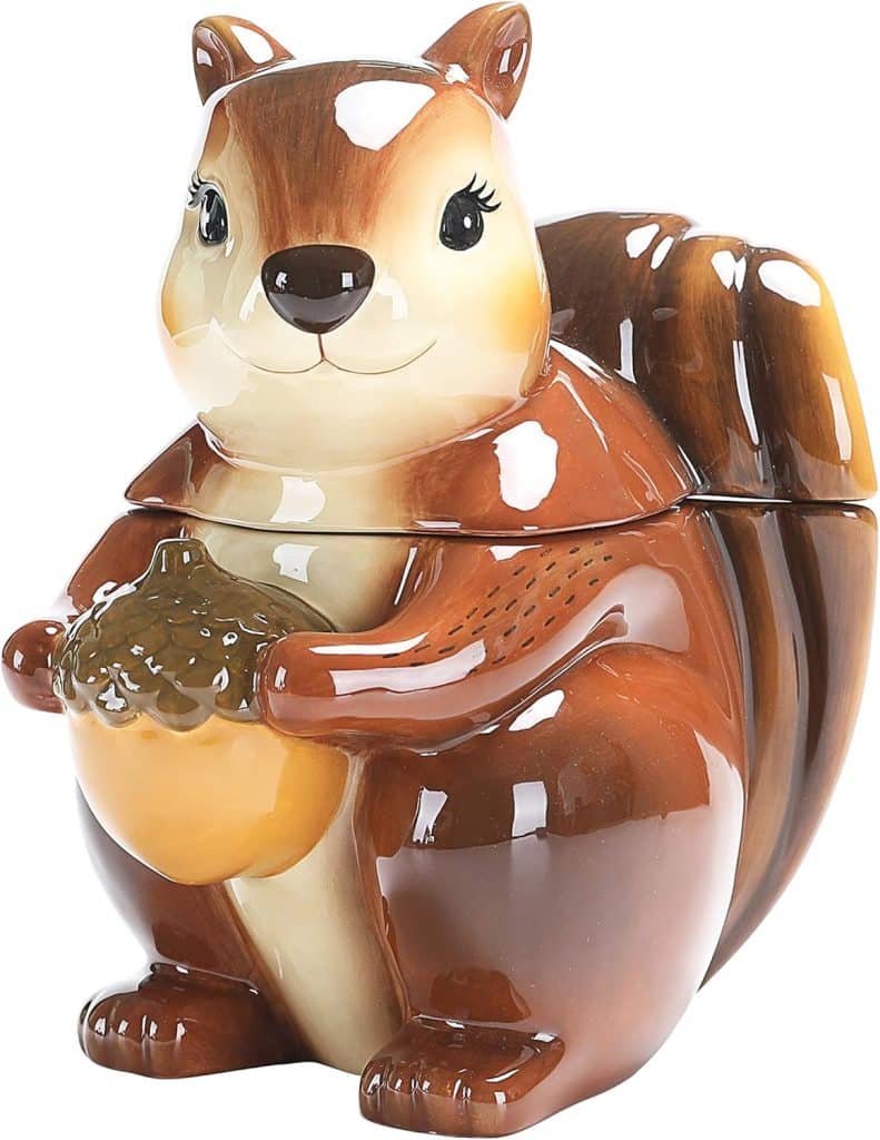 A glossy ceramic cookie jar shaped like a smiling brown squirrel holding an acorn, with detailed features reminiscent of a classic cookie stamp shortbread design, and a removable lid forming the upper body and head.