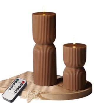 Two brown ribbed flameless pillar candles in different heights with glowing LED flames and remote control.