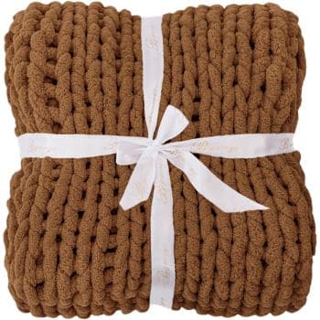 Brown chunky knit throw blanket folded and tied with a white ribbon on a white background.