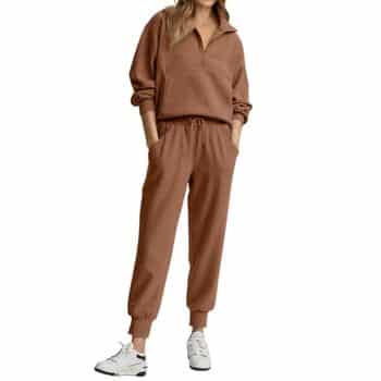 A person wearing a brown pullover sweatshirt and matching jogger pants with white sneakers, standing with hands in pockets. The face is not visible.