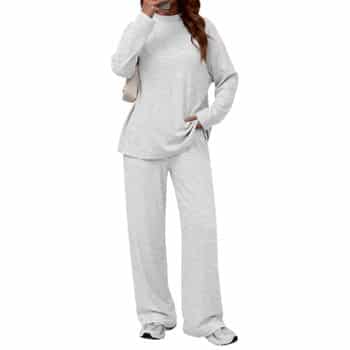A person wearing a loose-fitting, light gray sweatshirt and matching wide-leg sweatpants with white sneakers, standing against a plain background.