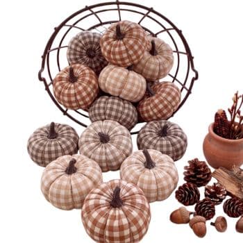 Collection of brown, beige, and cream gingham fabric pumpkins displayed in a rustic metal basket for fall.