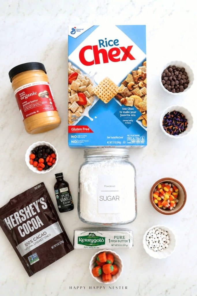 Overhead view of puppy chow ingredients including Chex cereal, chocolate chips, peanut butter, butter, vanilla extract, cocoa powder, and powdered sugar
