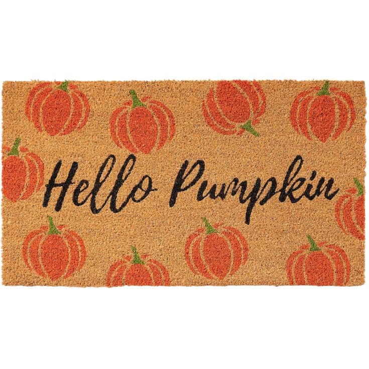 A doormat with the text “Hello Pumpkin” in black cursive surrounded by orange pumpkins on a tan background.