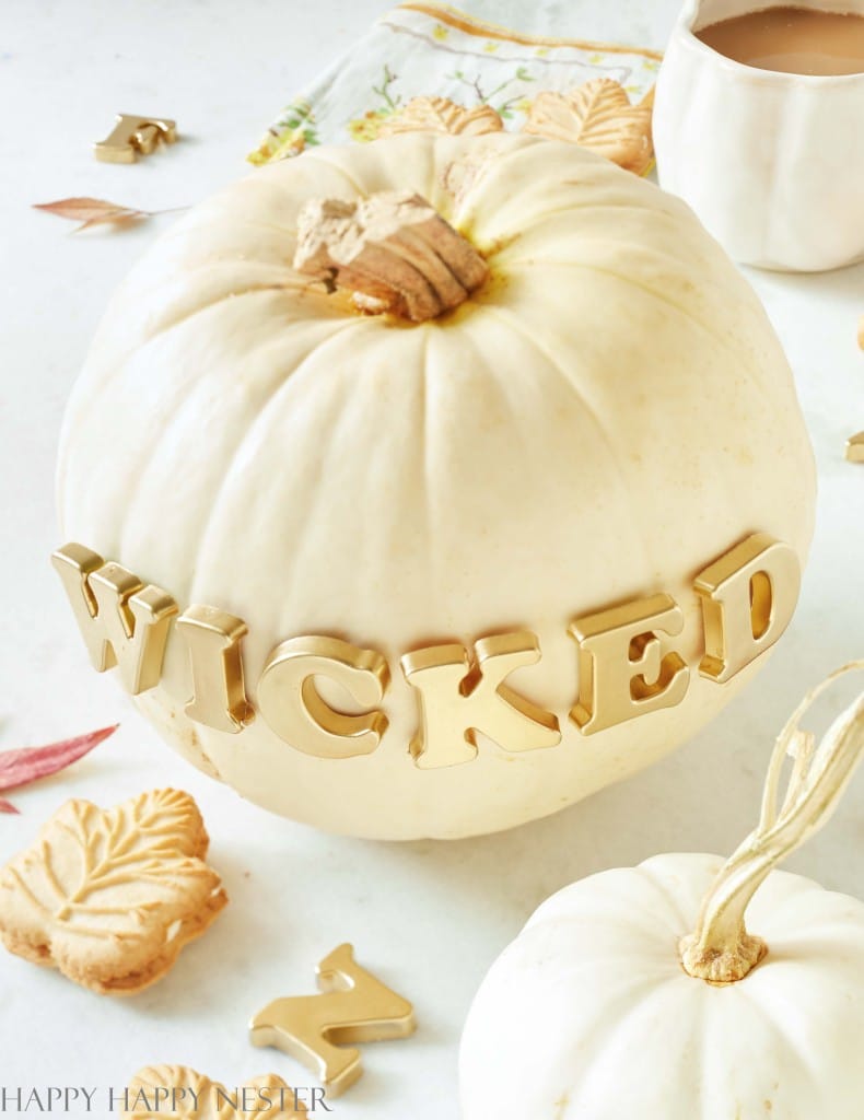 White pumpkin decorated with gold magnetic letters spelling WICKED for an easy no-carve Halloween pumpkin.