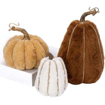 Set of three fuzzy fabric pumpkins in cream, caramel, and warm brown with rustic curved stems.
