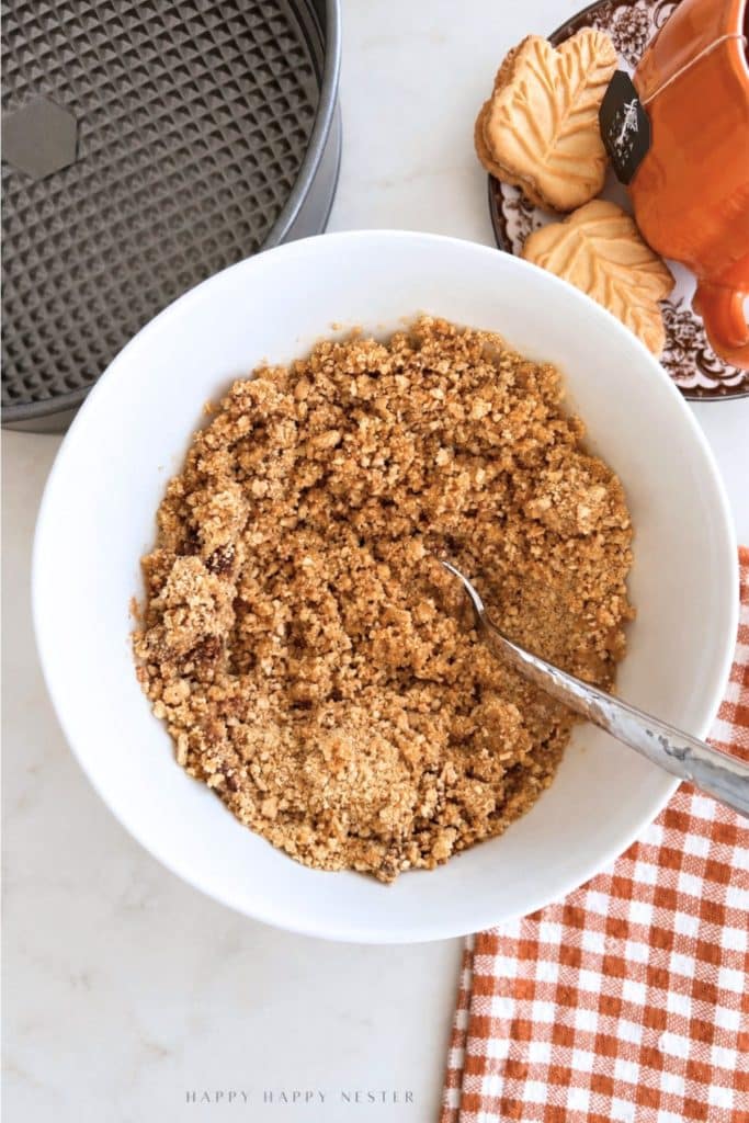 Graham cracker crust mixture with butter, sugar, and cinnamon for no bake pumpkin cheesecake.