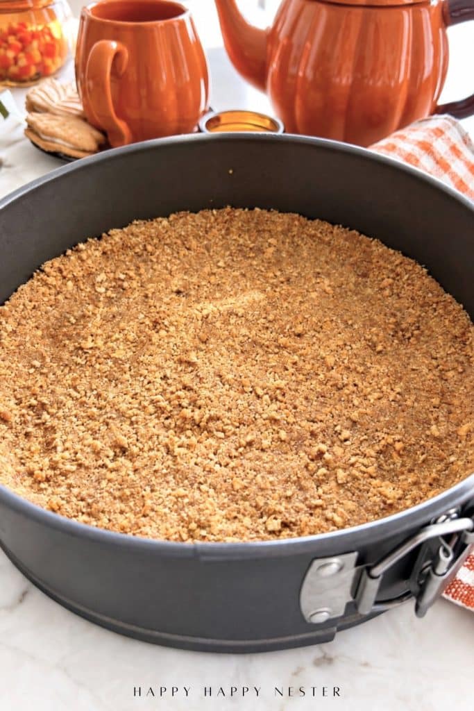 Graham cracker crust pressed into a 9-inch springform pan for no bake pumpkin cheesecake.