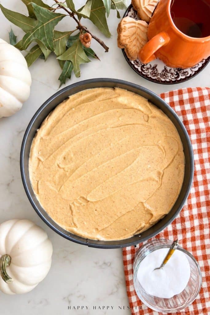 No bake pumpkin cheesecake filling spread evenly in a springform pan before chilling.