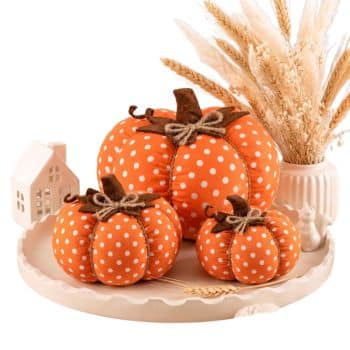 Three orange fabric pumpkins with white polka dots styled on a fall tray