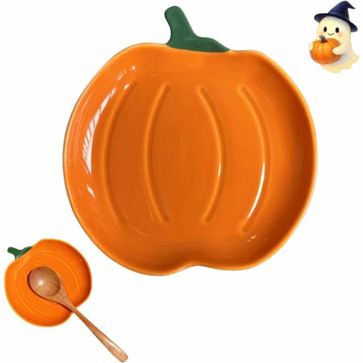 Orange pumpkin-shaped plate with green stem, a smaller matching dish with a wooden spoon, and a cartoon ghost wearing a witch hat holding a pumpkin in the top right corner.