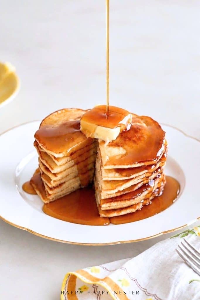 Stack of homemade pancakes with butter and maple syrup showing the tender interior