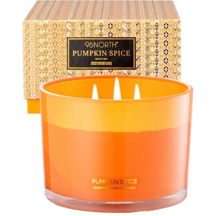 Orange soy candle labeled “Pumpkin Spice” with three wicks, in front of a patterned box displaying the same scent and brand, 96NORTH.