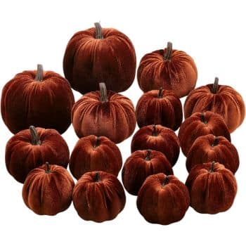 Large collection of rust orange velvet pumpkins in assorted sizes with natural-looking brown stems.