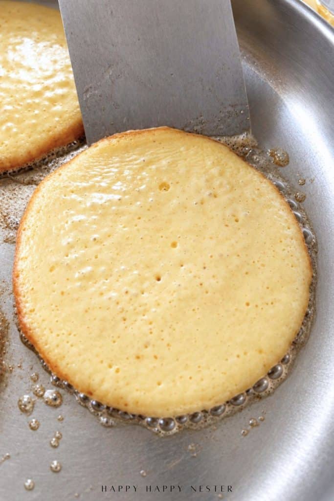 Spatula underneath a homemade pancake that is ready to be flipped in the skillet