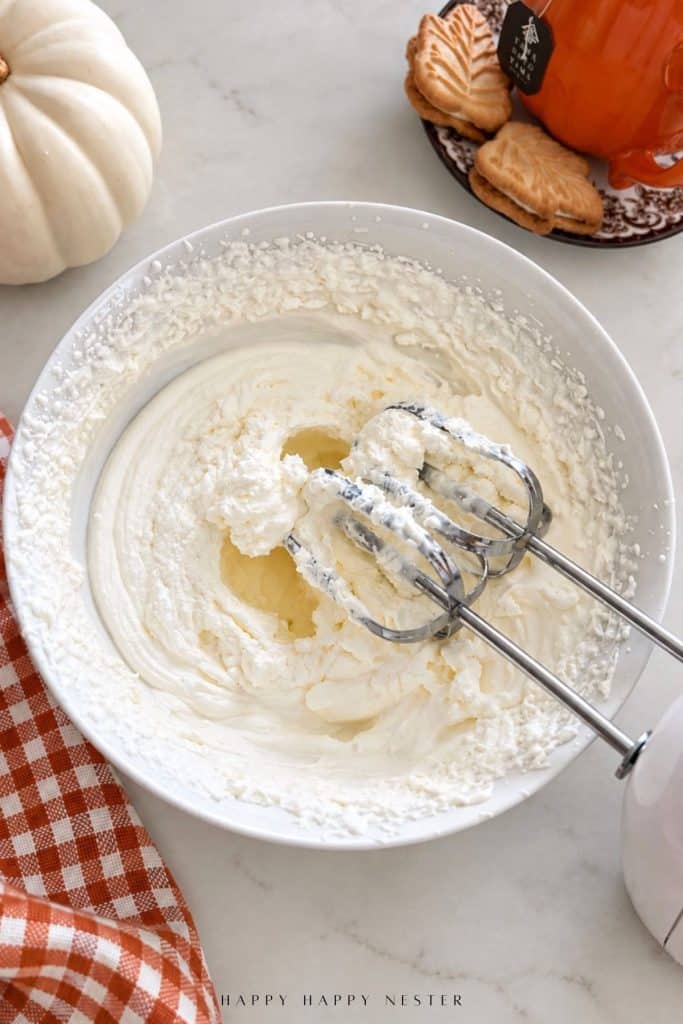Heavy whipping cream beaten until thick and fluffy for no bake pumpkin cheesecake filling.