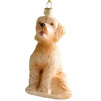Golden dog glass Christmas ornament hanging on a tree.