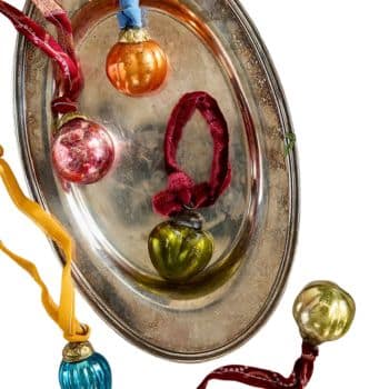 Small vintage-style glass Christmas ornaments in orange, pink, green, blue, and gold.