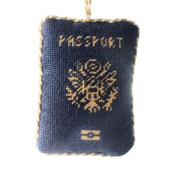 Navy blue embroidered passport Christmas ornament with gold stitching.