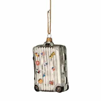 Silver suitcase Christmas ornament hanging on an evergreen tree.