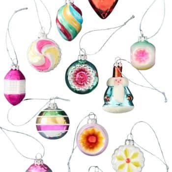 Collection of colorful vintage-style glass Christmas ornaments on a blue background.