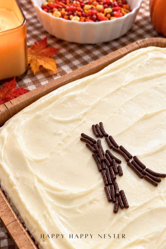 Chocolate sprinkles arranged into a tree trunk on a white-frosted Trader Joe's sheet cake for an easy fall decorating project.