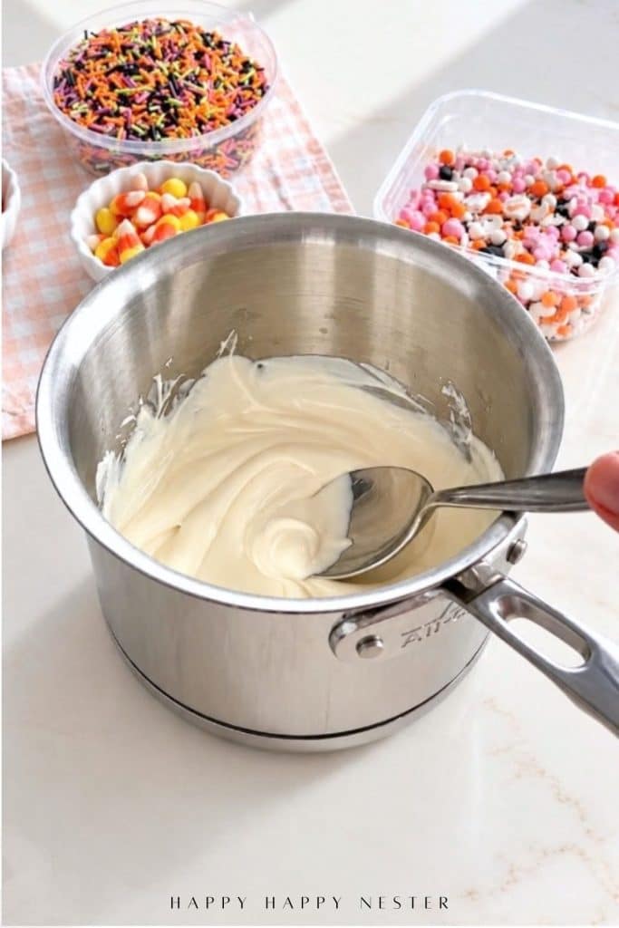 Smooth melted white almond bark in a stainless steel saucepan.