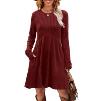 Burgundy ribbed knit dress with long sleeves, crew neckline, fitted waist, flared skirt, and pockets, paired with a brown handbag.